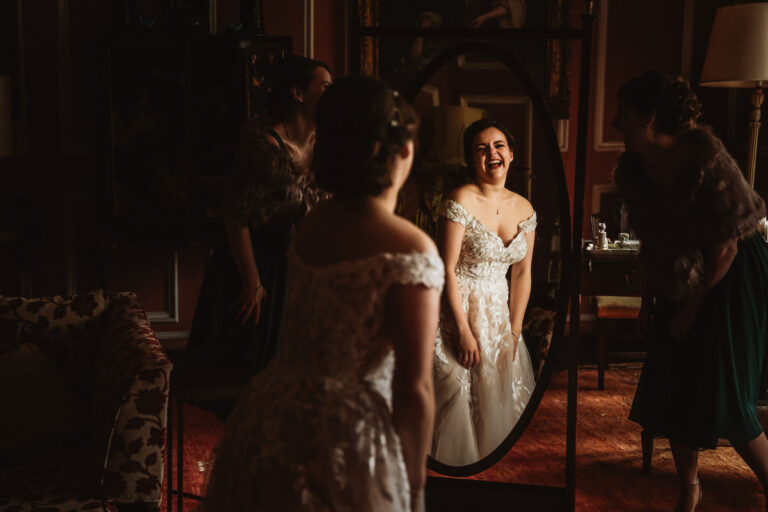 Reflection of Bride laughing in a mirror at Thrumpton Hall before she gets married at St Nic's Church.